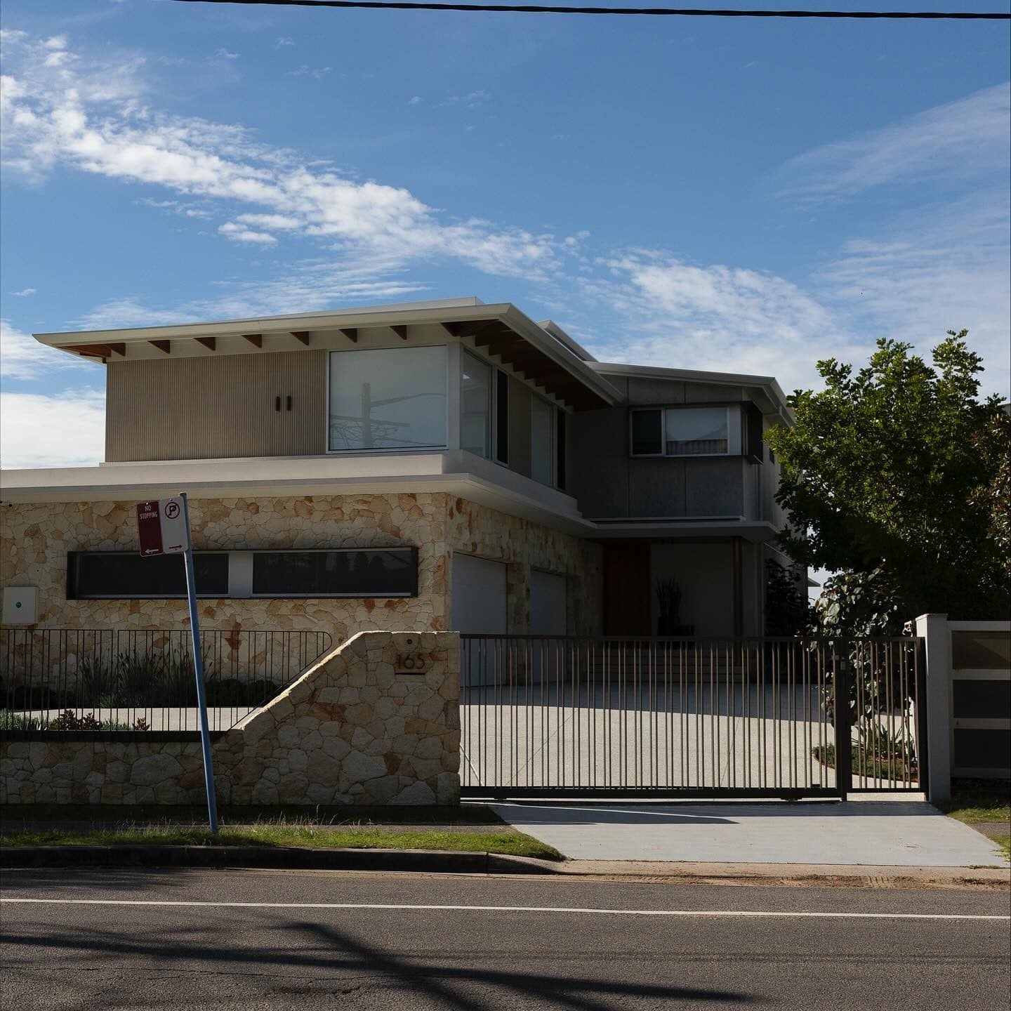 Street frontage — stainless powder-coated fence line and gate