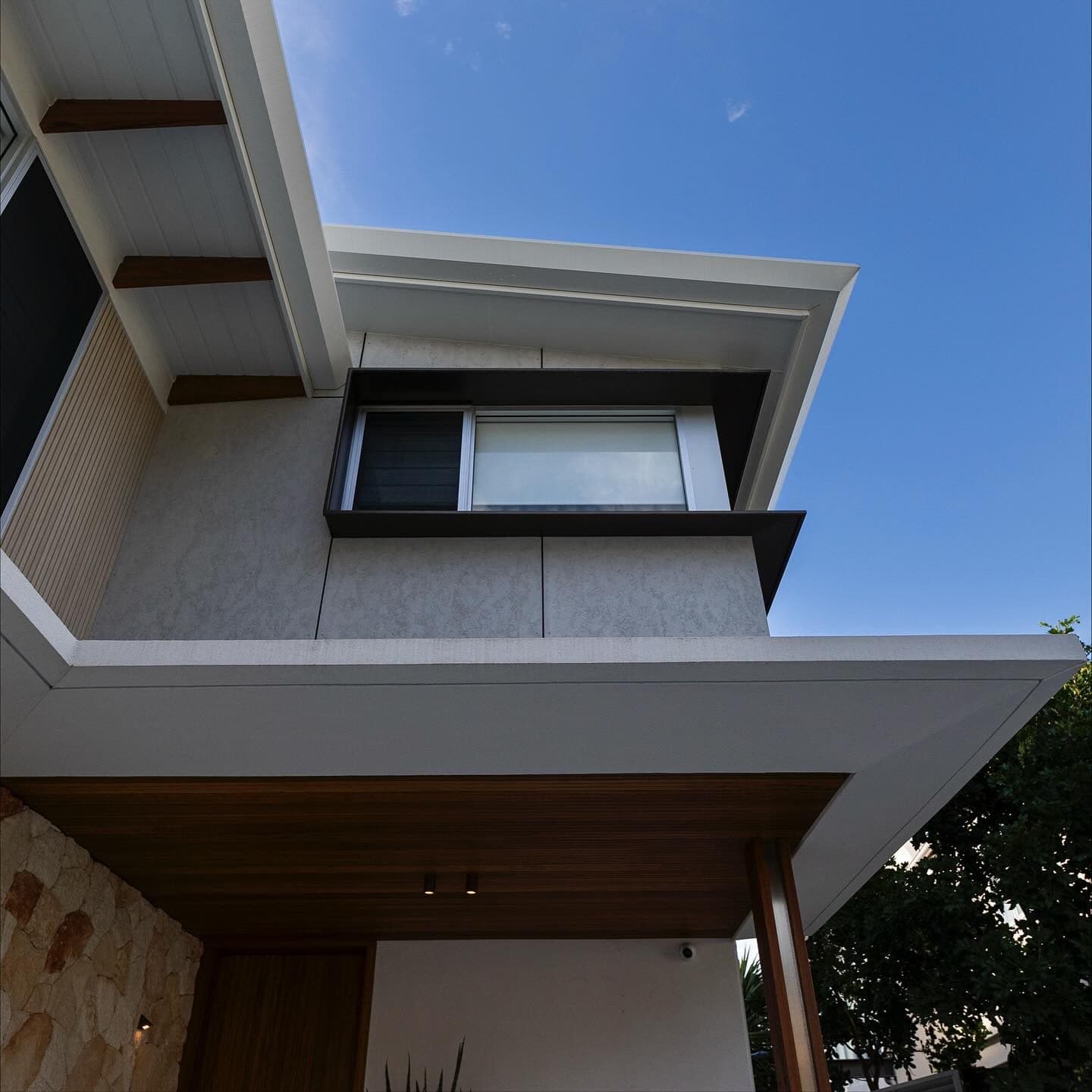 Aluminium window hood over the entry, timber soffit above