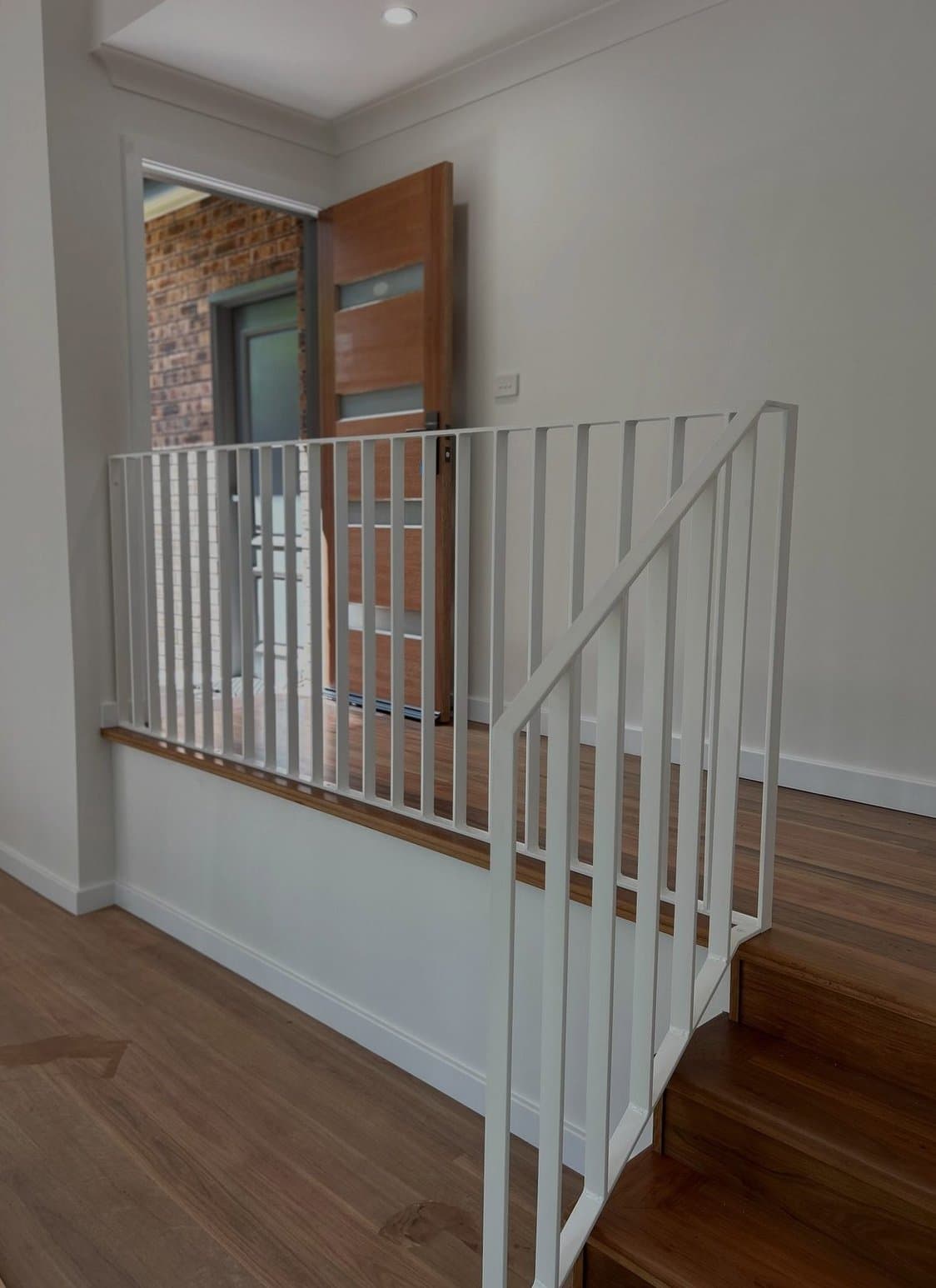 White flat-bar balustrade at the timber entry steps
