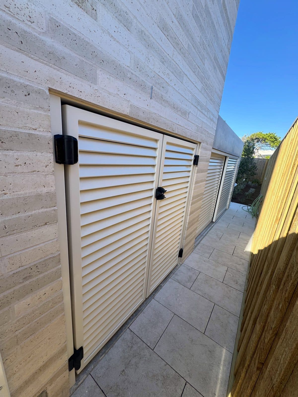 Louvred garage doors in the travertine laneway